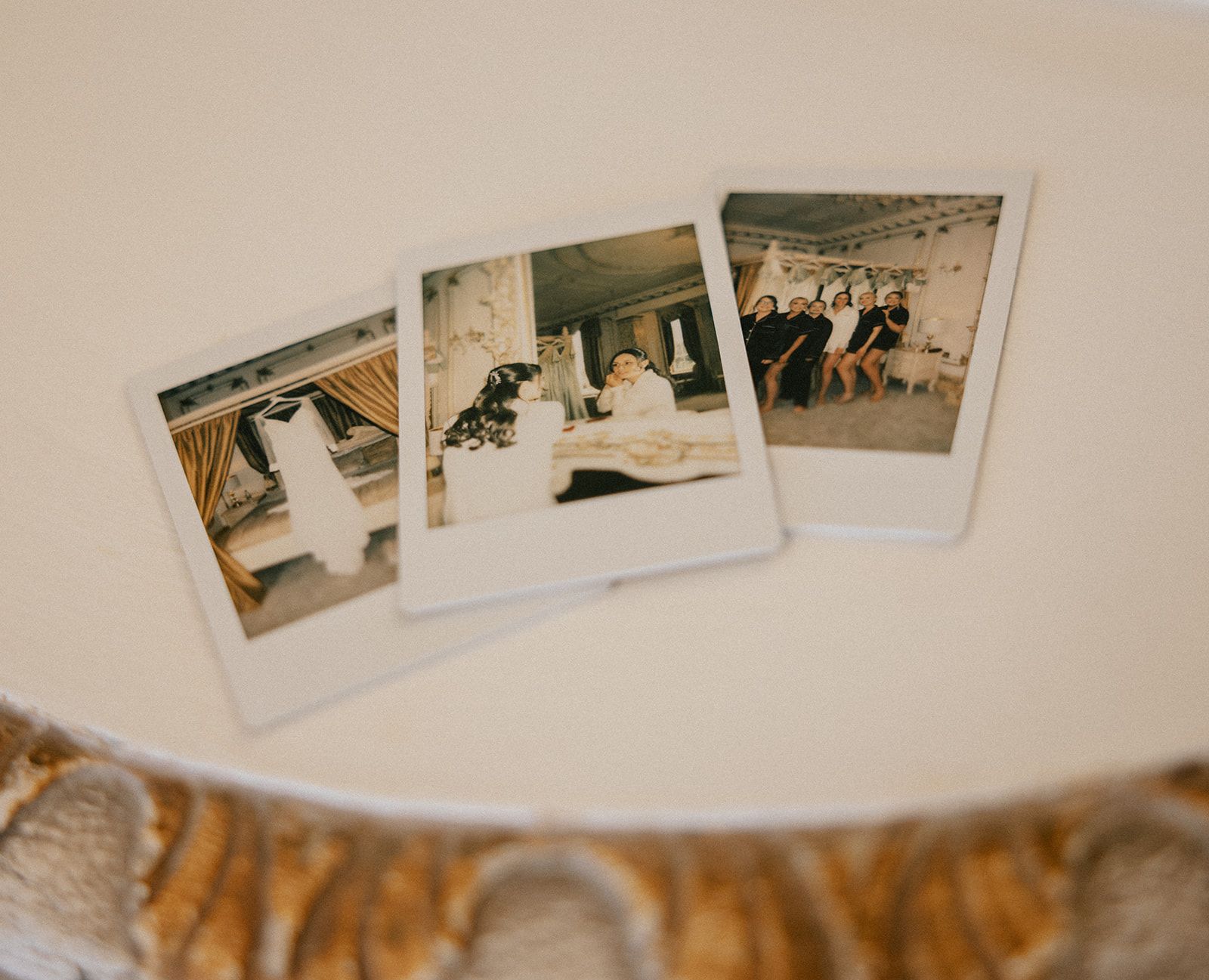 Three polaroid pictures of a bride and groom are sitting on a table.