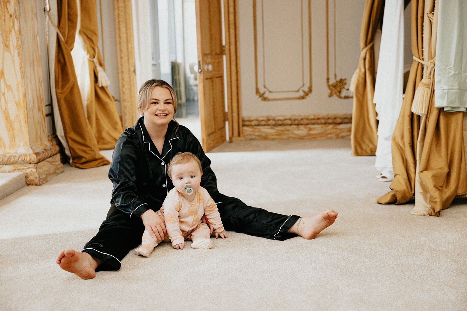 A woman is sitting on the floor with a baby.