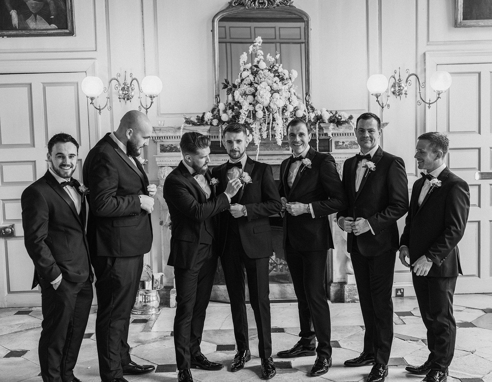 A group of men in suits and bow ties are standing next to each other in a room.