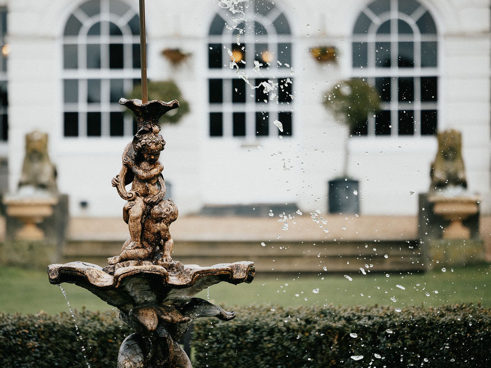 A fountain with a statue in front of a building