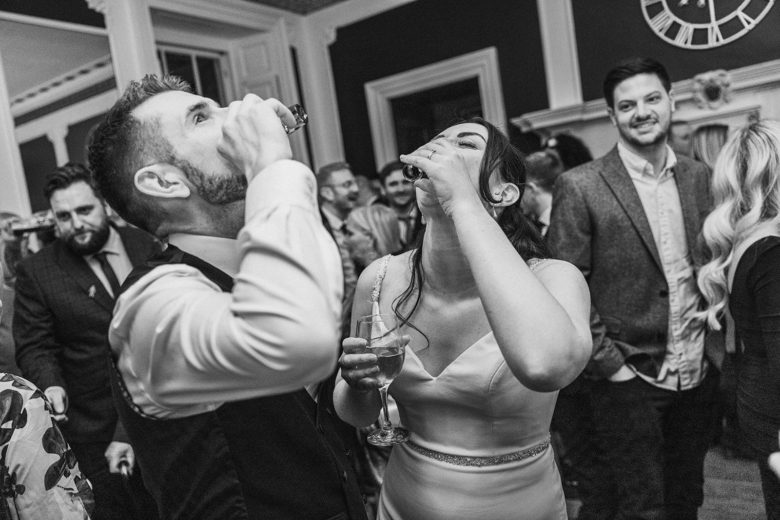 A black and white photo of a bride and groom dancing at a wedding reception.