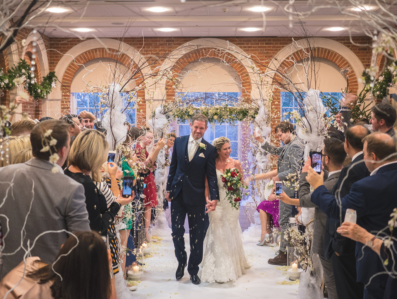 A bride and groom are walking down the aisle at their wedding.