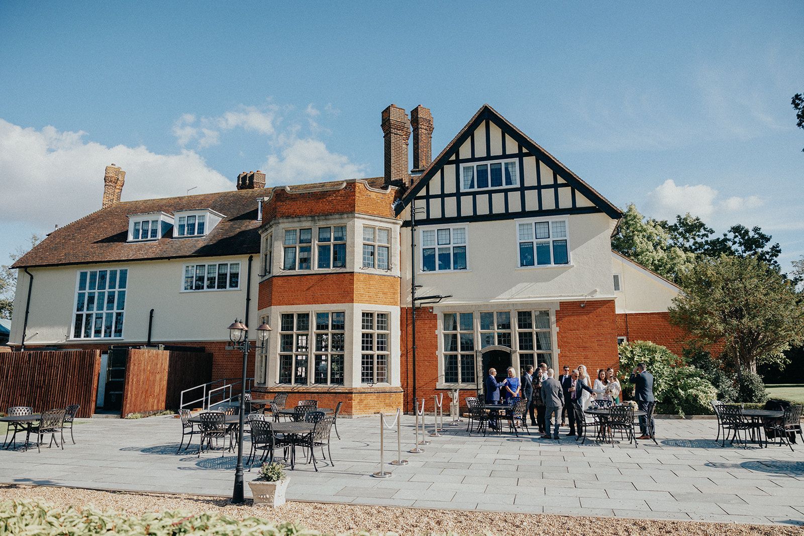 A group of people are standing in front of a large house.