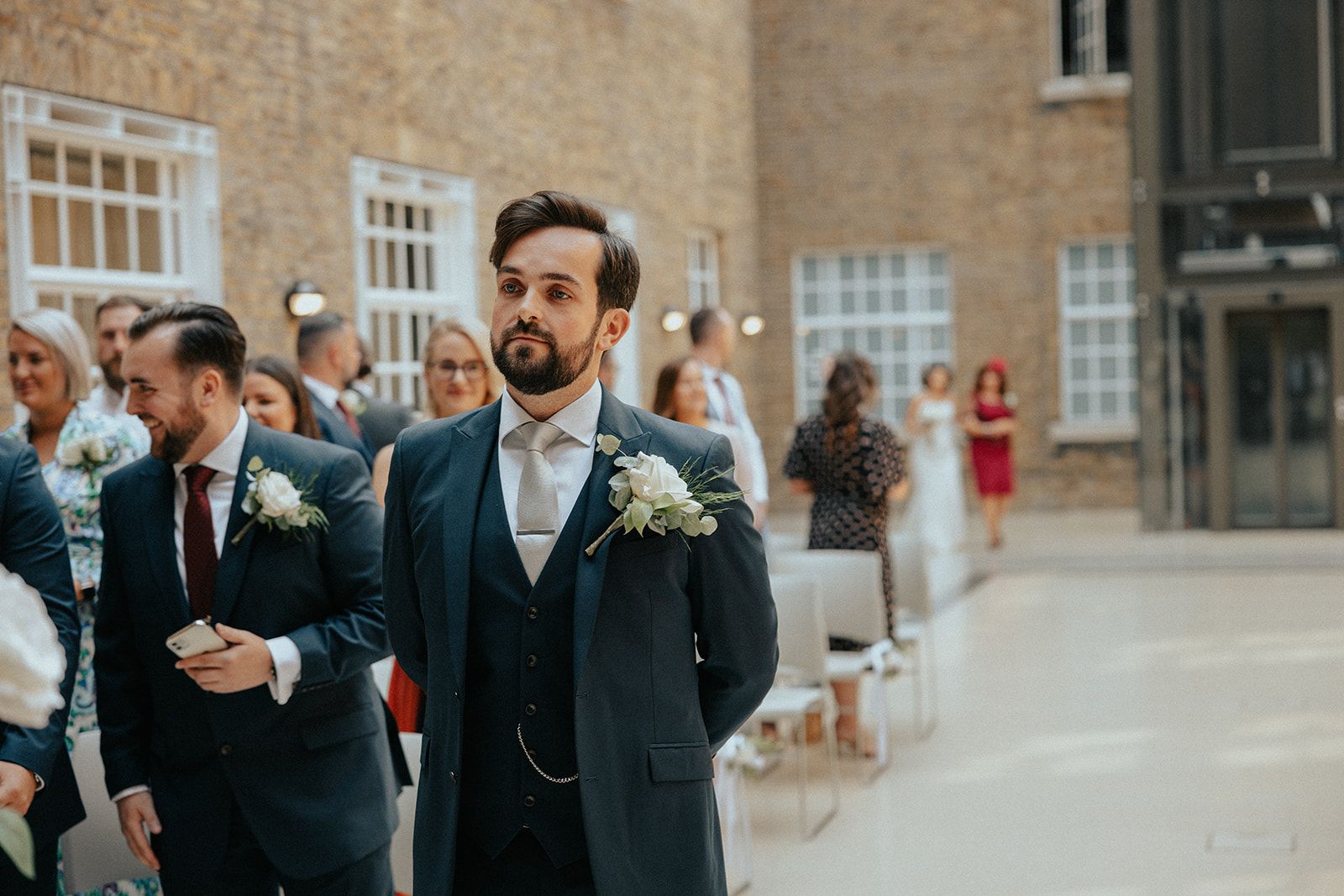 A man in a suit and tie is walking down the aisle at a wedding.