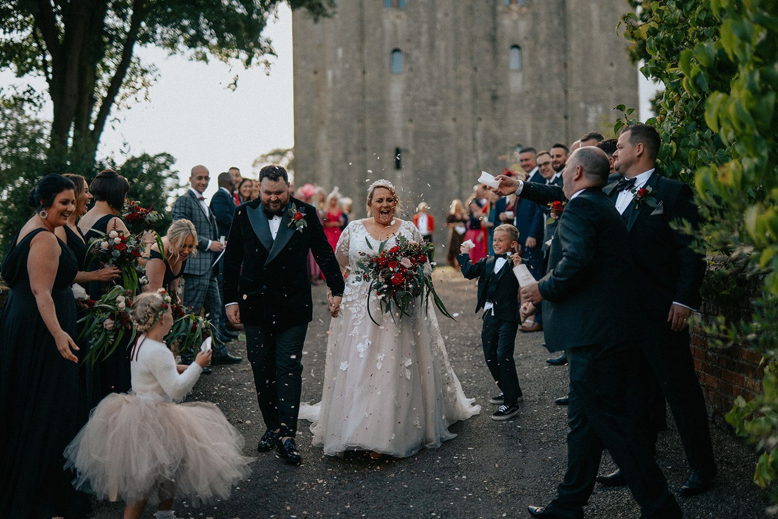 A bride and groom are walking down the aisle surrounded by their wedding party.