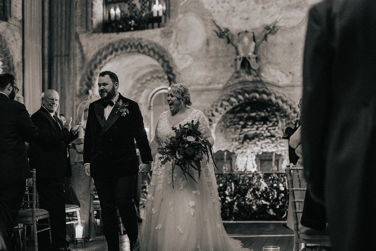 A bride and groom are walking down the aisle at their wedding.