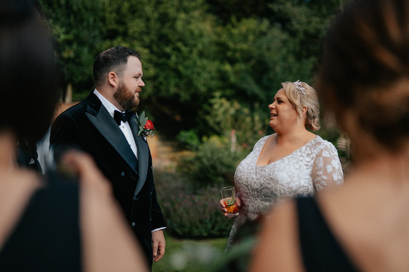 A bride and groom are standing next to each other in front of their wedding party.