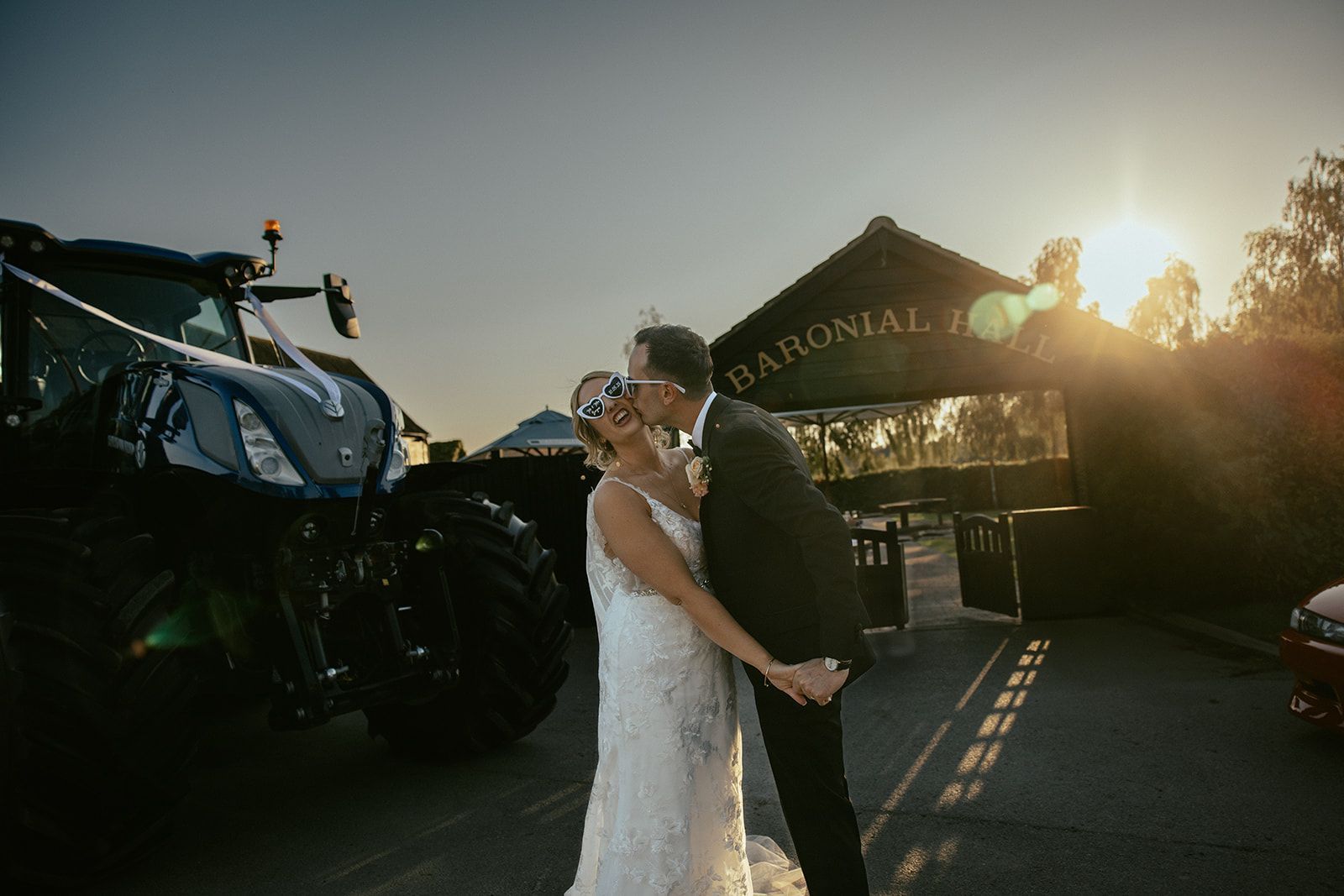 A bride and groom are standing next to each other in front of a brick wall.