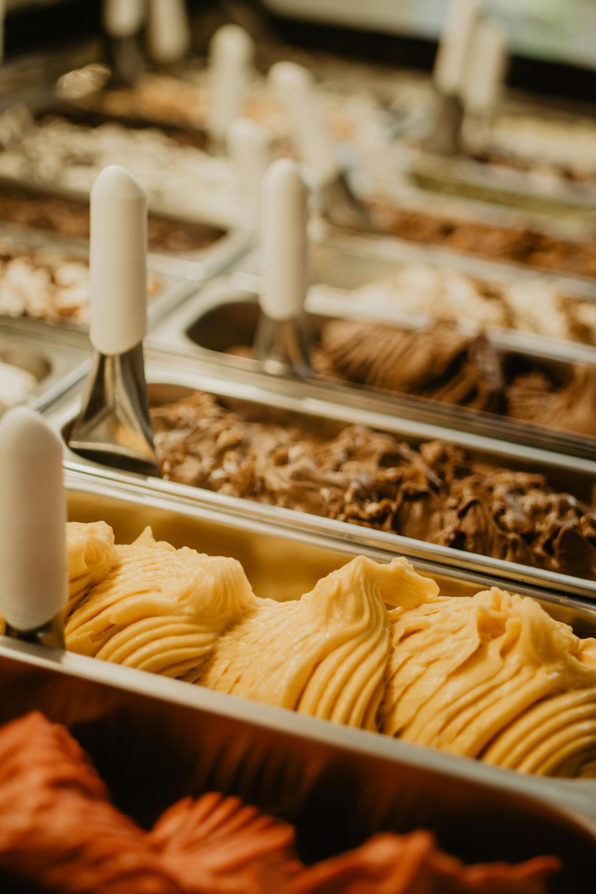 Chocolate chip cookies on a cooling rack next to a rolling pin, on a light-colored surface.
