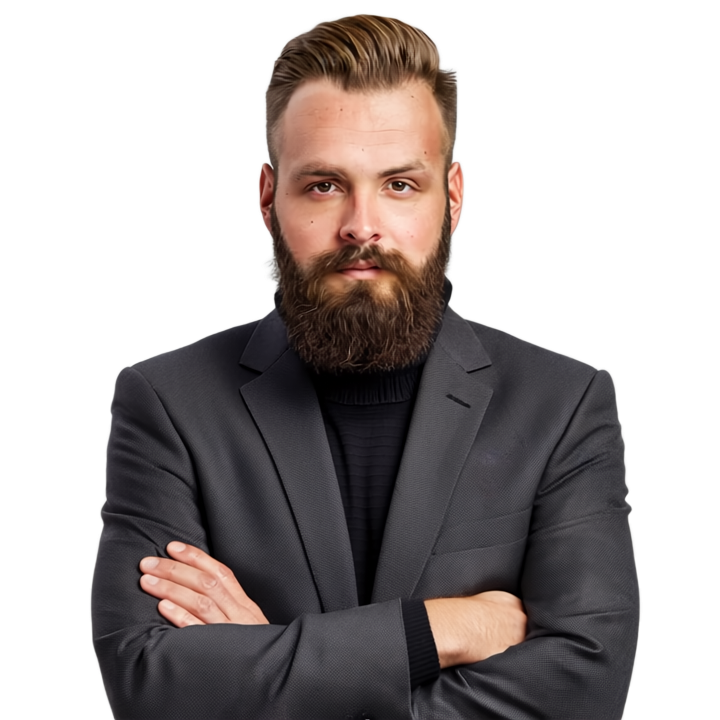 Mann mit Vollbart, schwarzem Rollkragenpullover und grauem Anzug, die Arme verschränkt, blickt den Betrachter an.