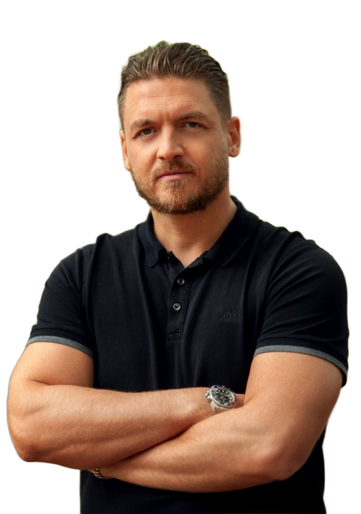 Mann mit verschränkten Armen, schwarzes Poloshirt tragend, im Freien.