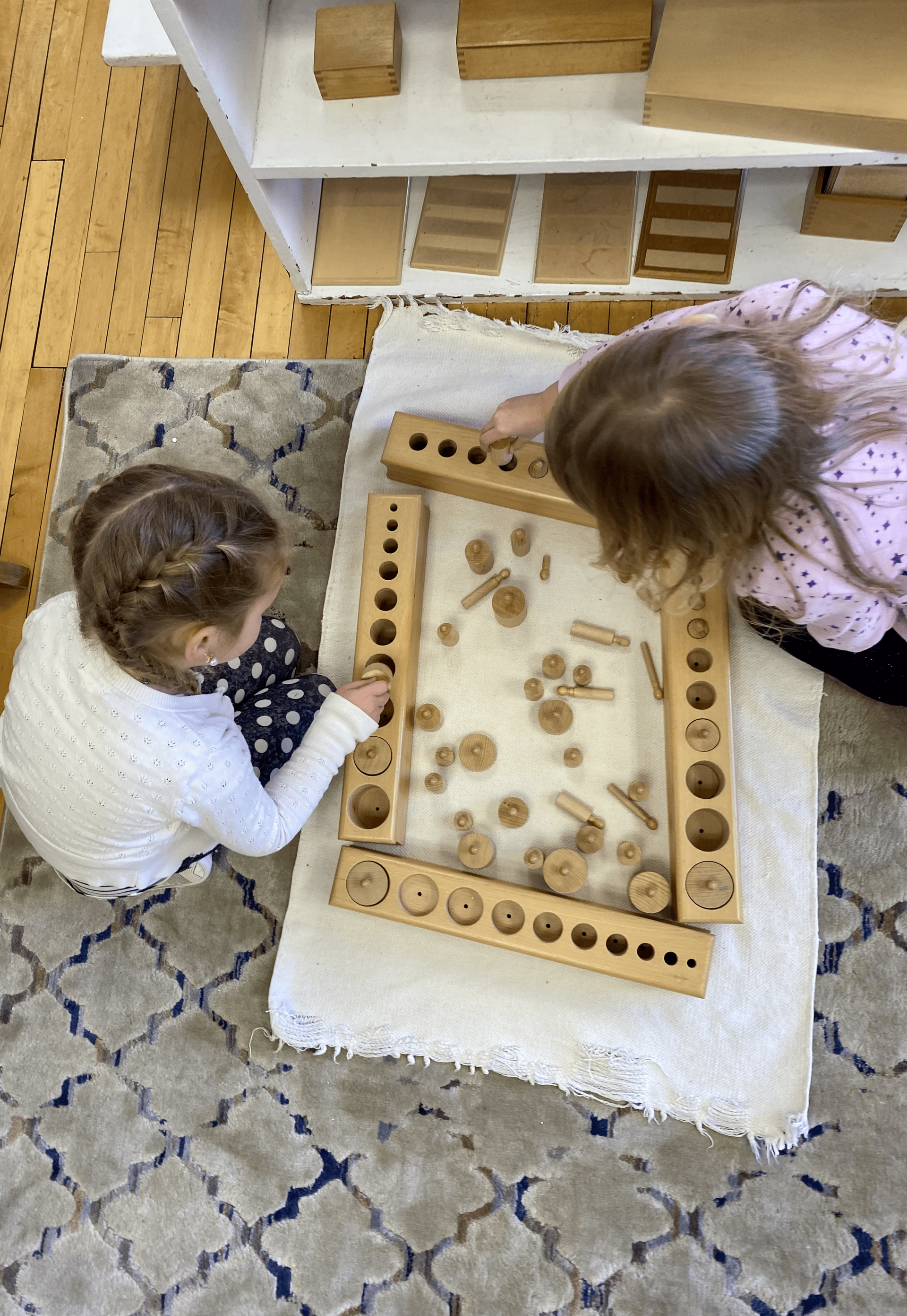 montessori children working with knob cylinders