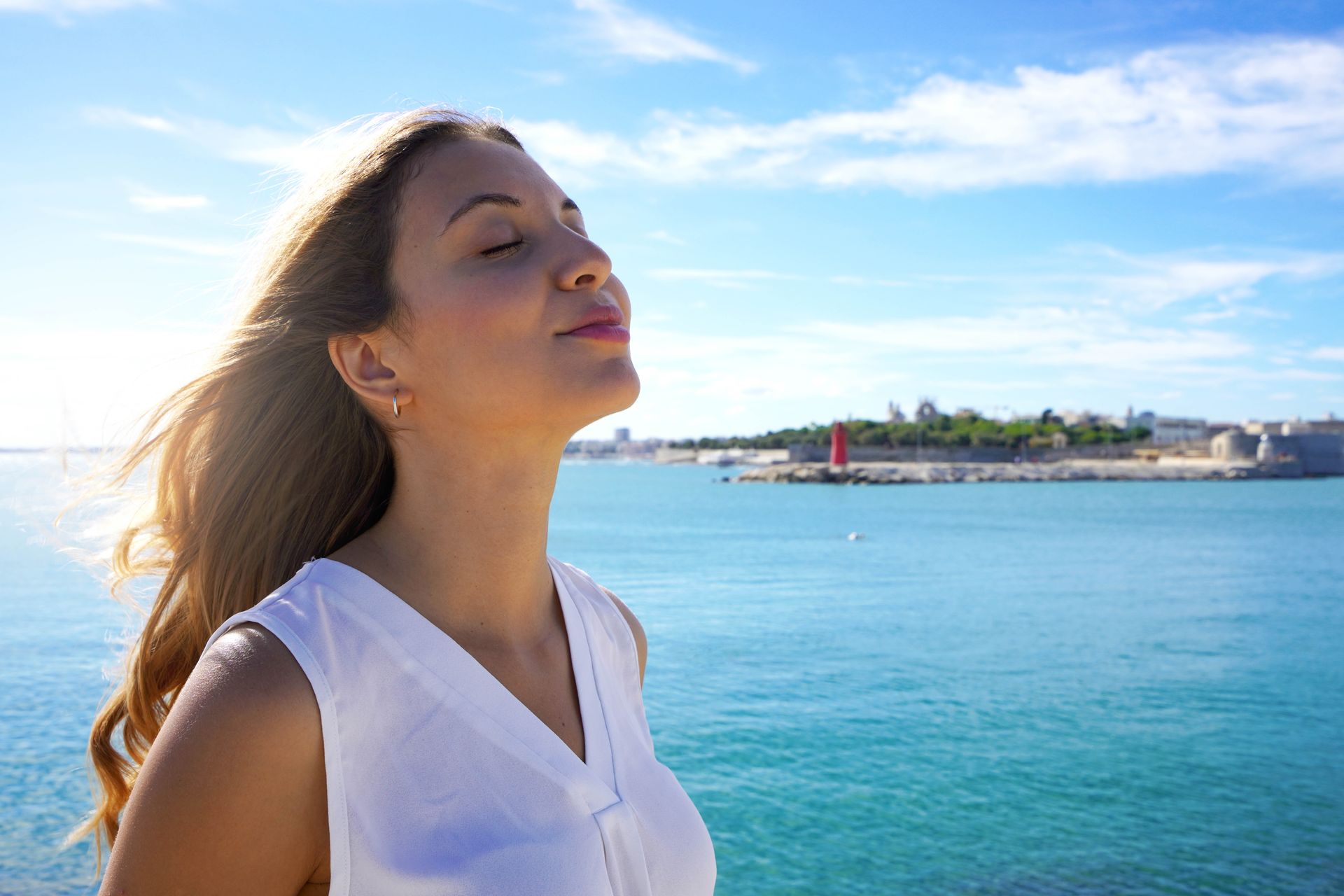 A woman is breathing fresh air for nasal relief.