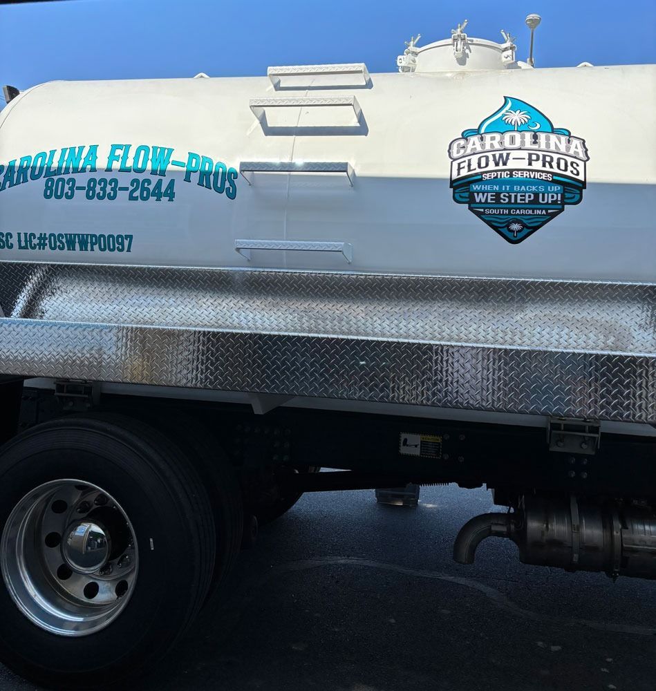 White Carolina Flow-Pros septic truck with logo and phone number, parked outside.