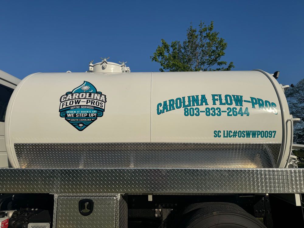 White Carolina Flow-Pro tank truck with logo and contact info parked outdoors.