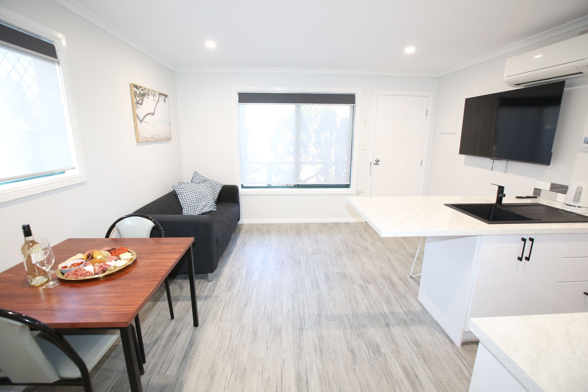 A living room with a couch , table , chairs and a television.