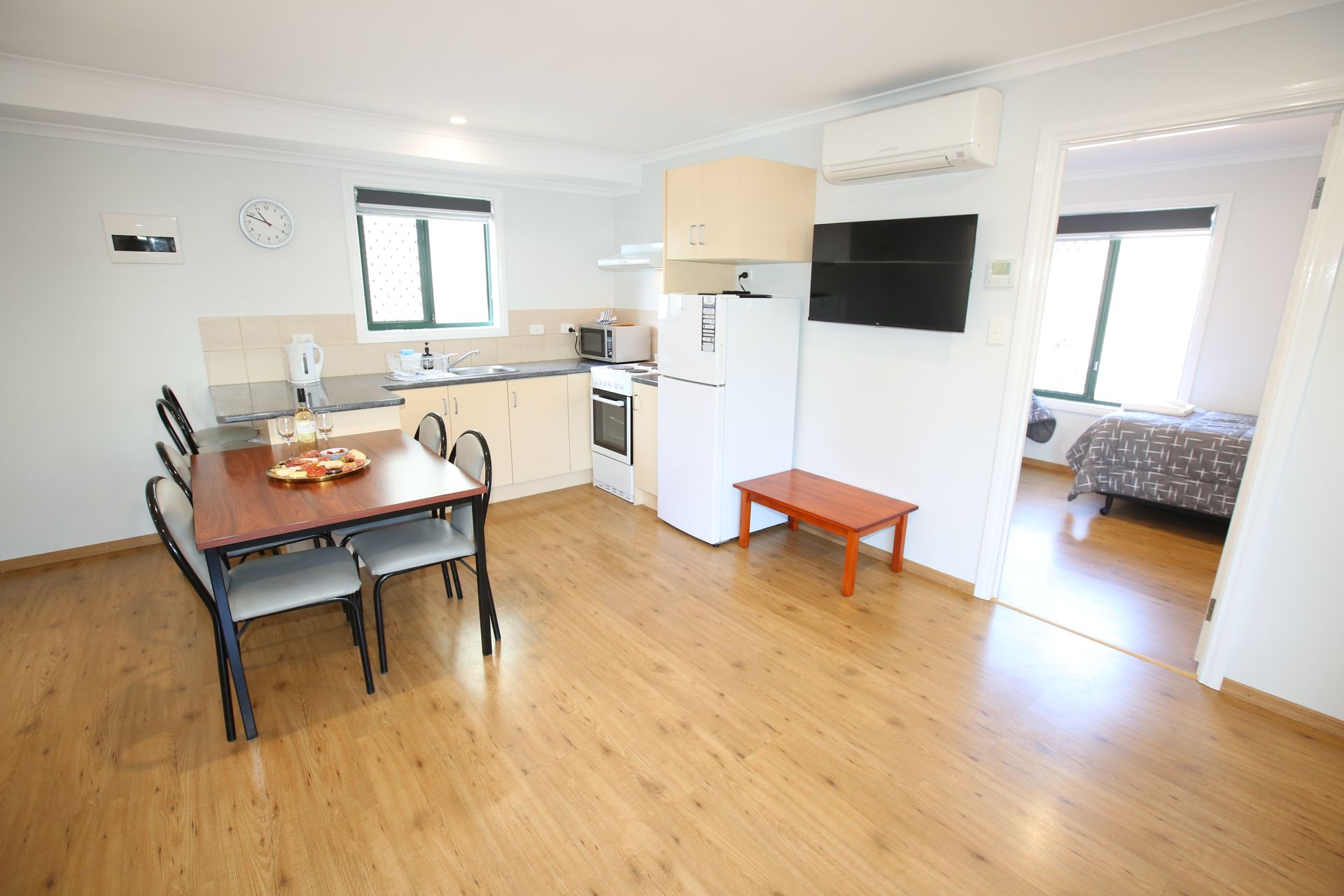 A living room with a table and chairs and a kitchen.