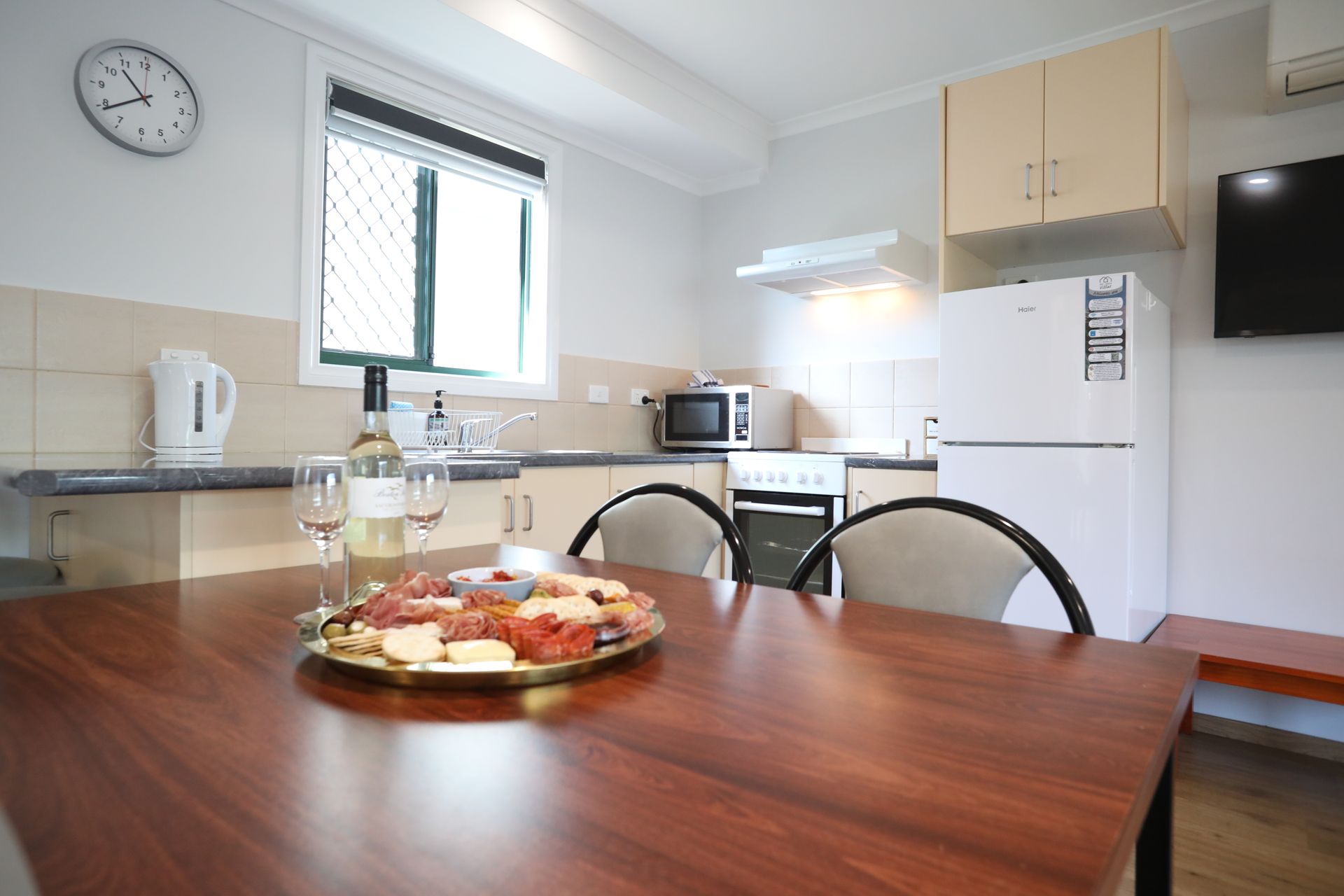A kitchen table with a plate of food and a bottle of wine on it.