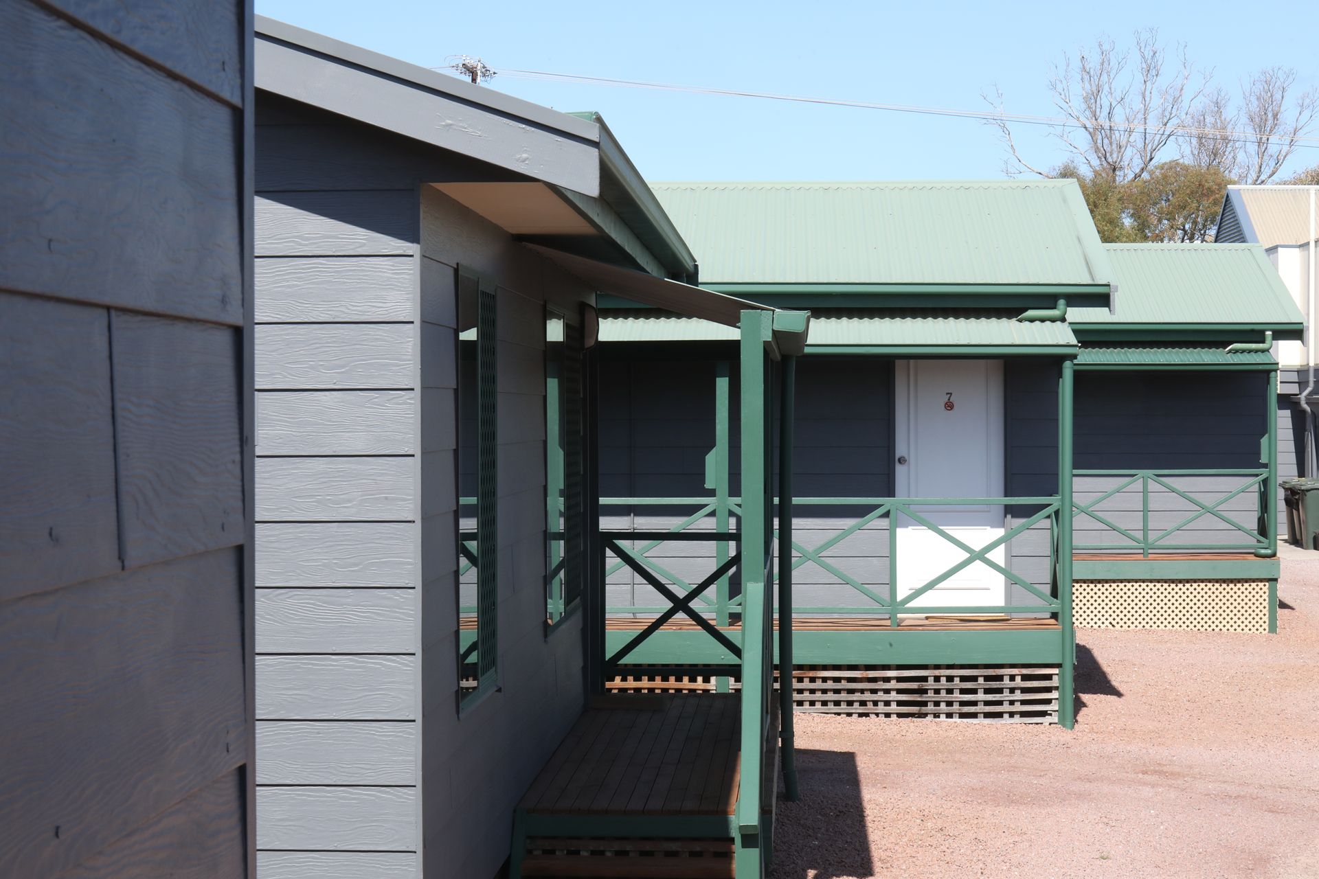 A house with a green porch and a white door
