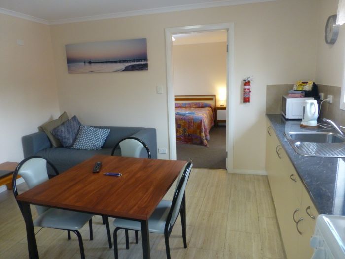 A kitchen with a table and chairs and a fire extinguisher on the wall