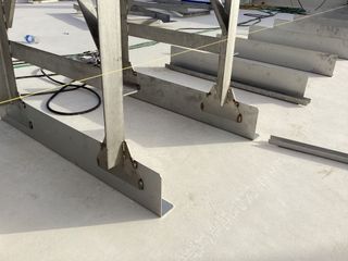 Metal stair sections on a white surface, possibly rooftop construction.