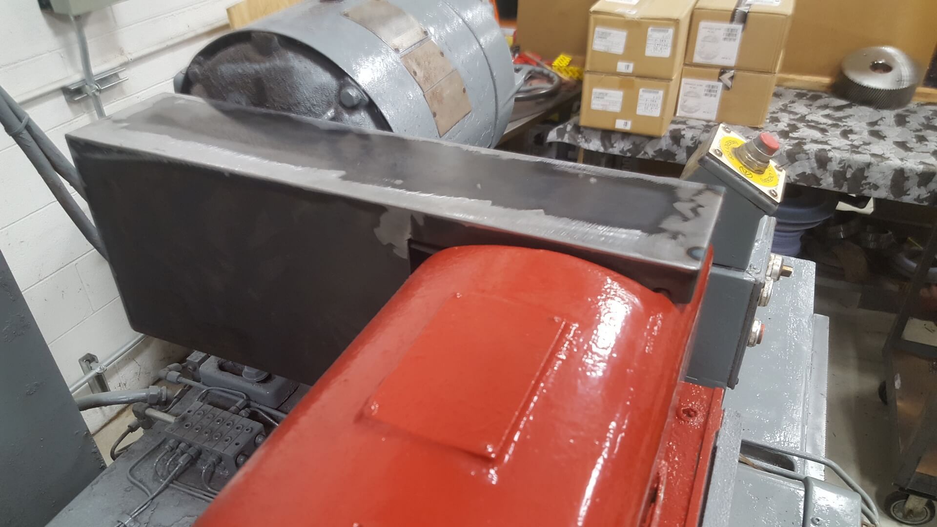 Red and gray industrial machine with a red motor and gray metal housing.