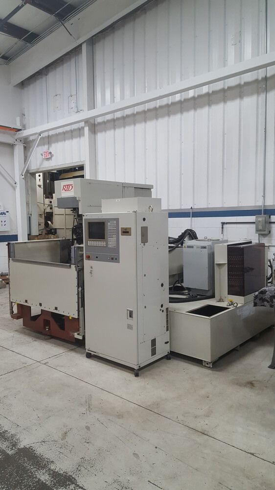 Large, off-white industrial machine with a control panel in a factory setting.