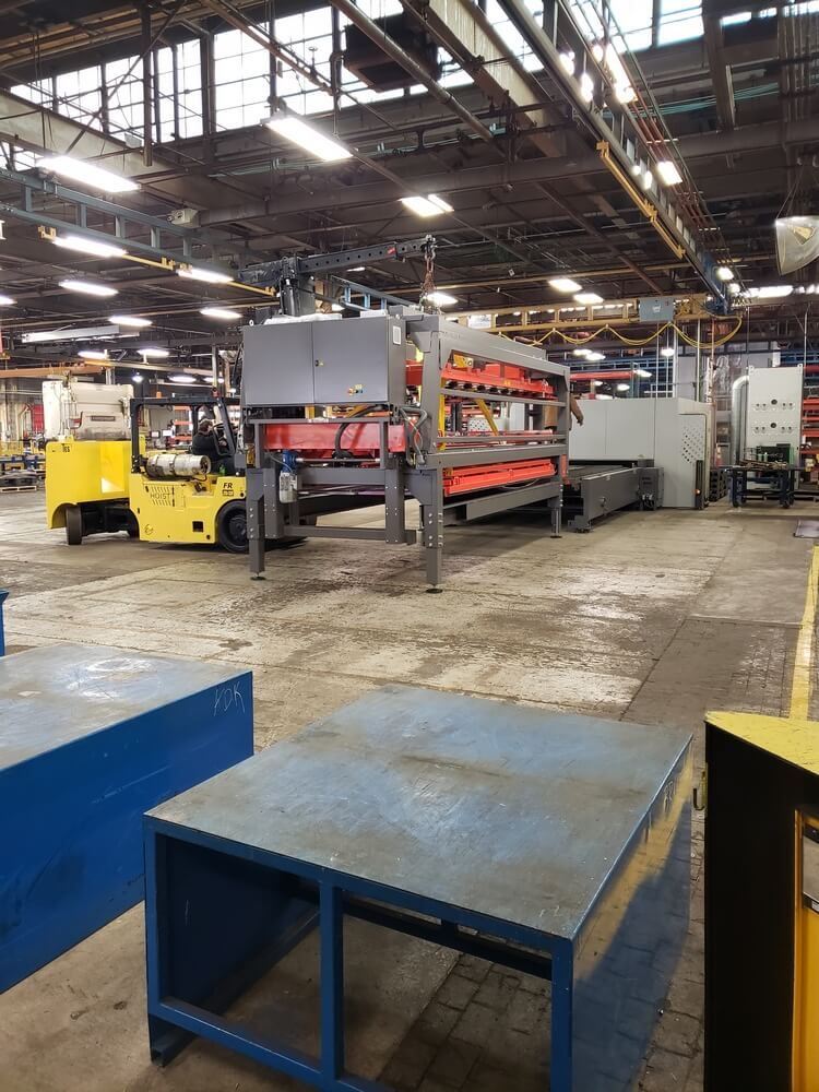 Forklift near industrial machinery inside a factory.