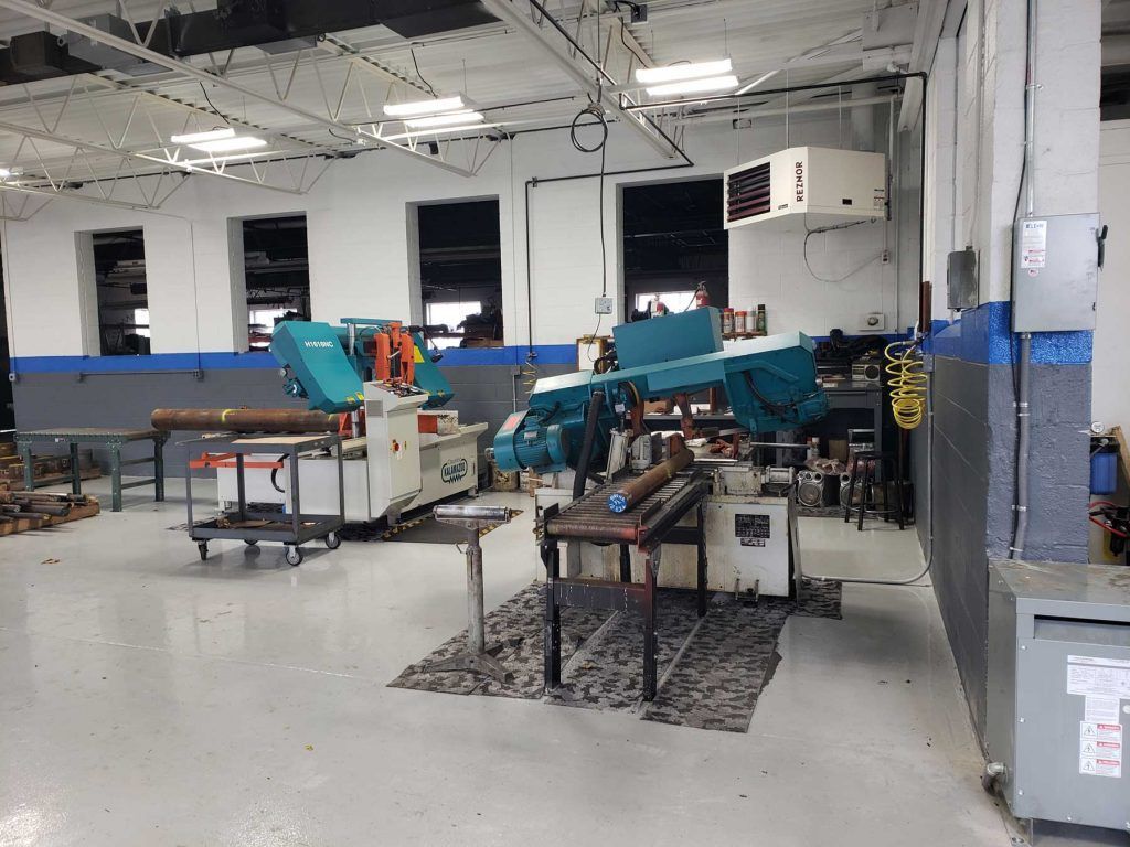 Workshop interior with machinery, tools, and a gray floor.