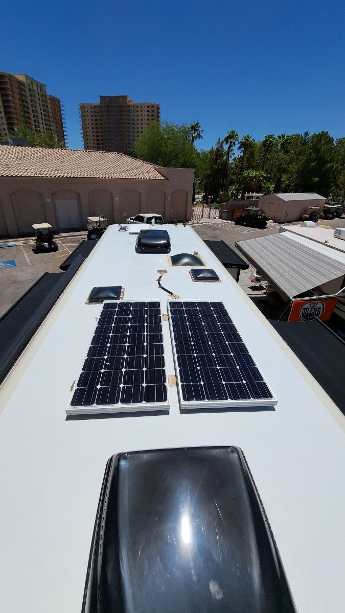 There are two solar panels on the roof of a bus.