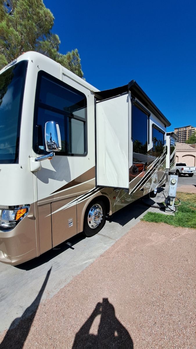 A large rv is parked on the side of the road.