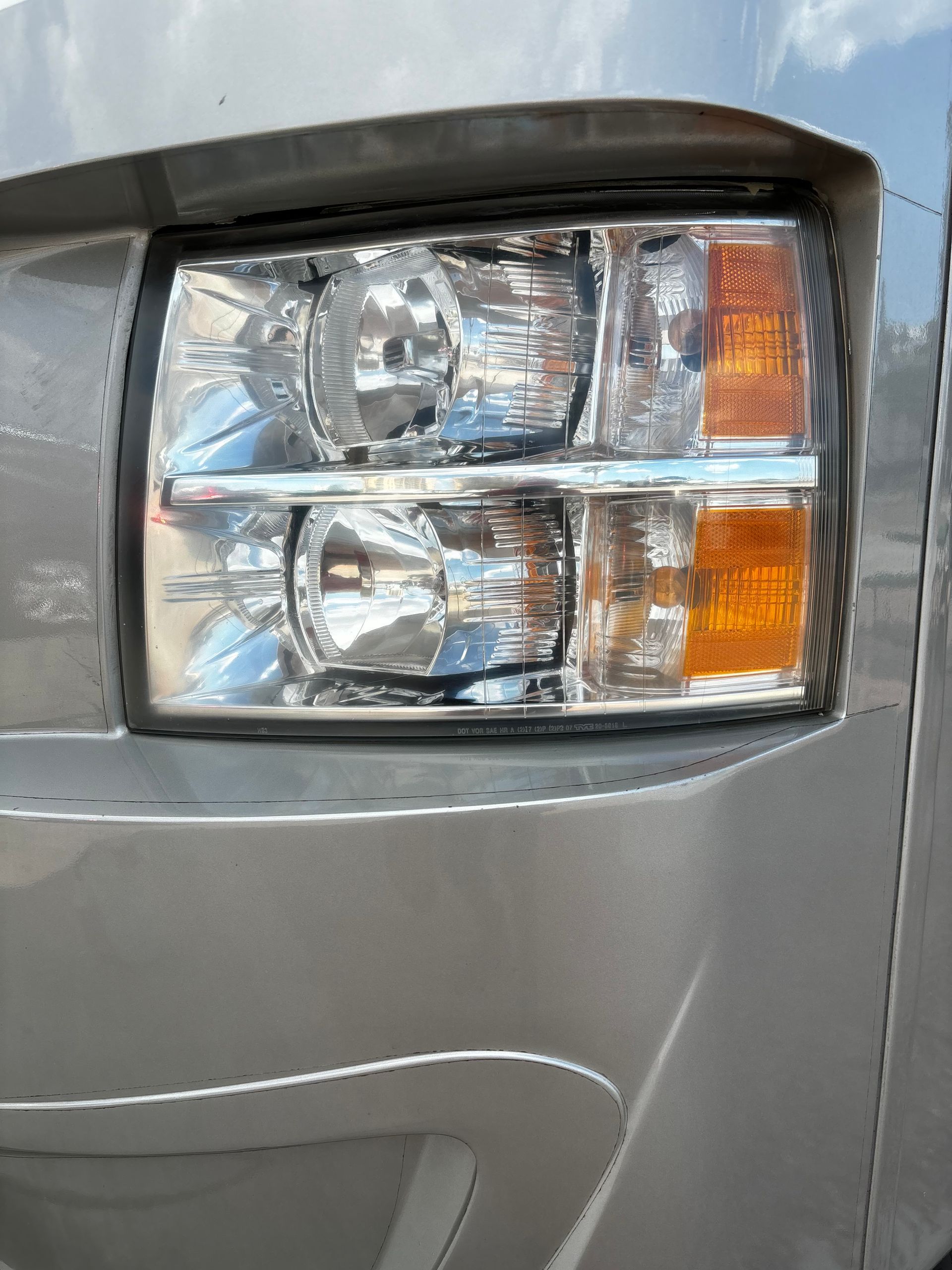 A close up of a car 's headlight on a sunny day.