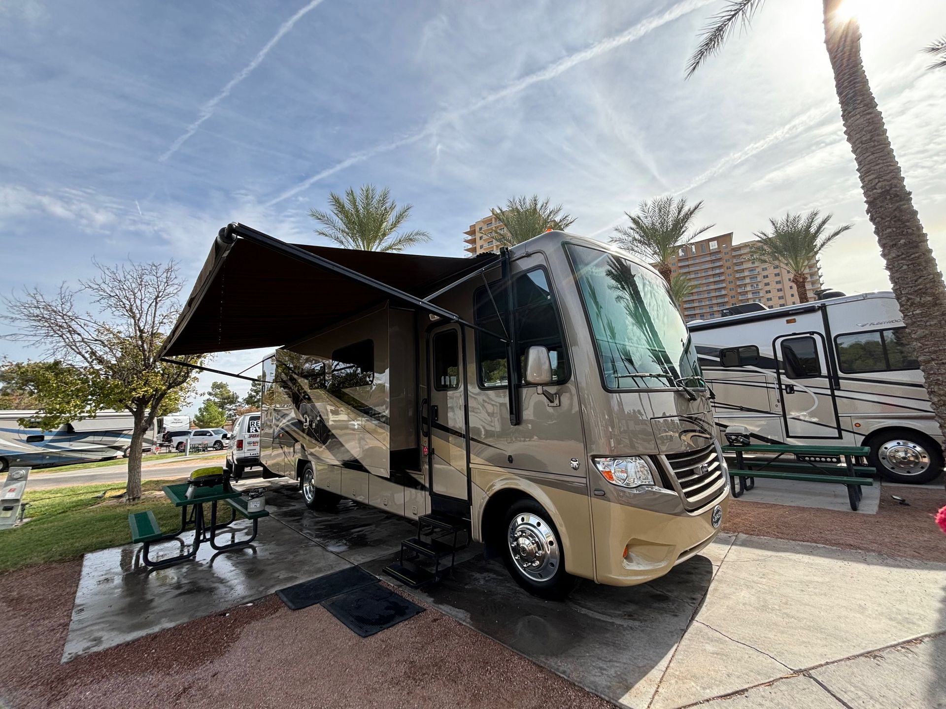 A black and white rv is parked in a gravel lot.