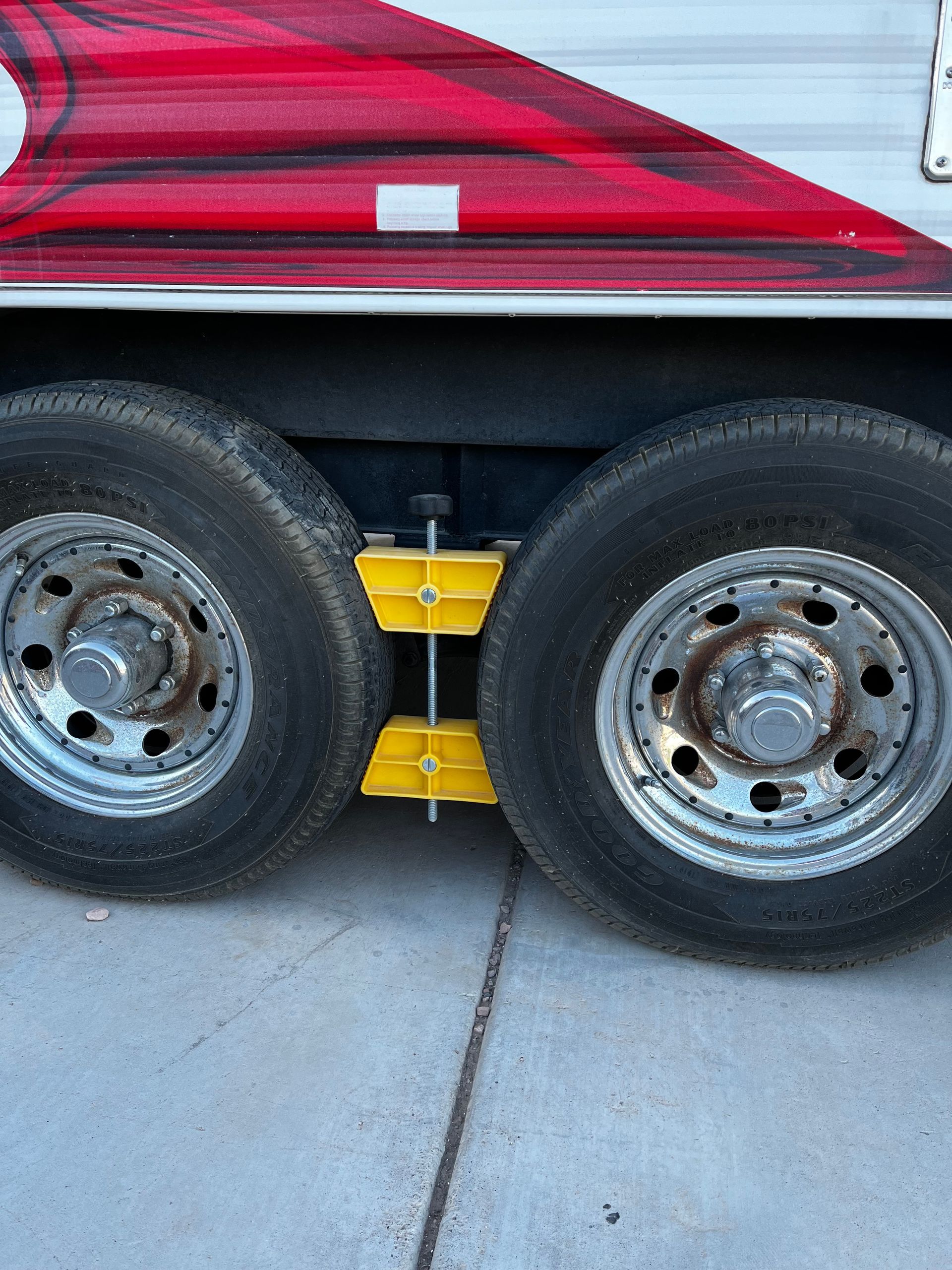 A close up of a trailer 's tires on a concrete surface.