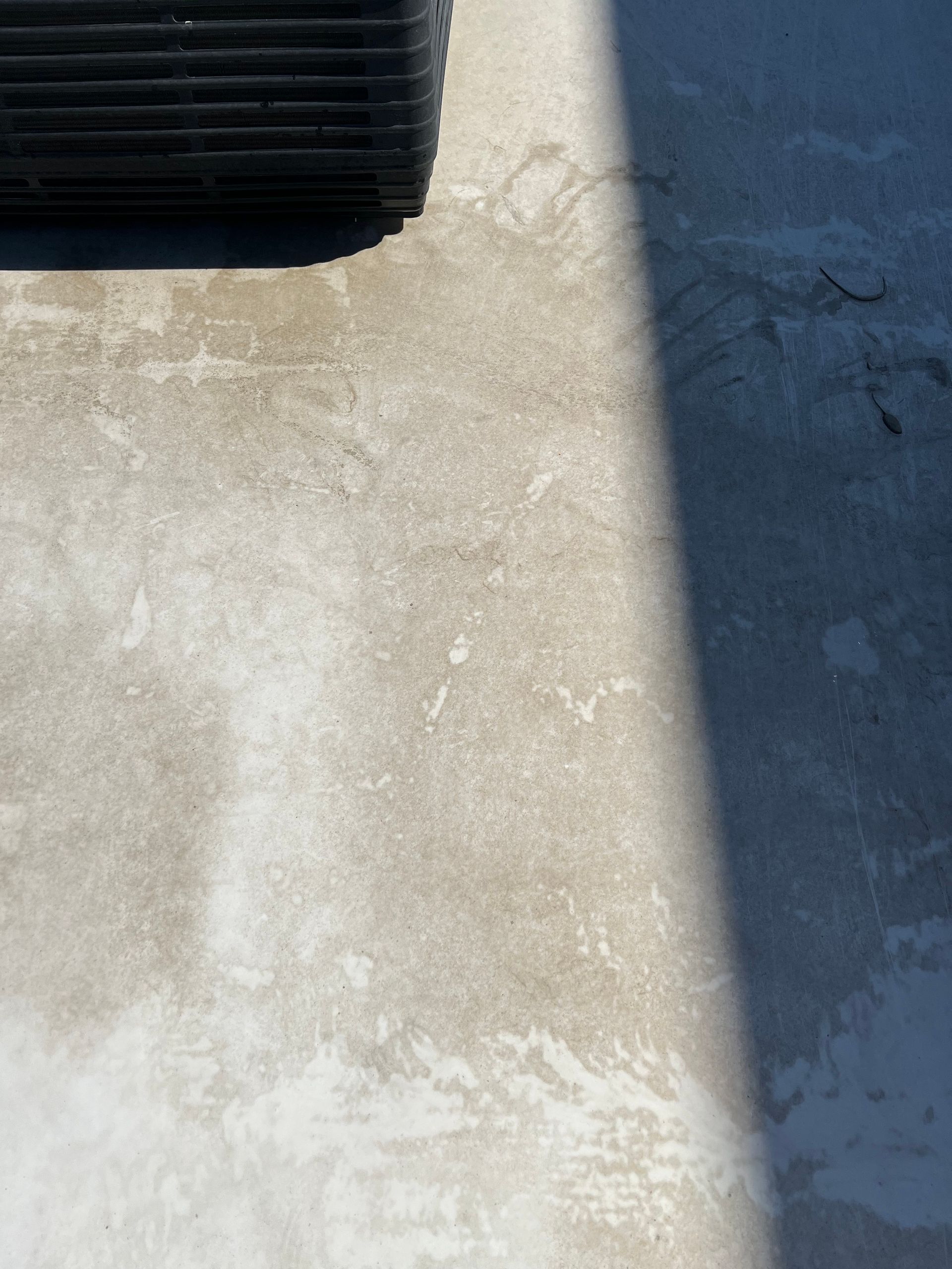 A shadow of a car is cast on a concrete surface