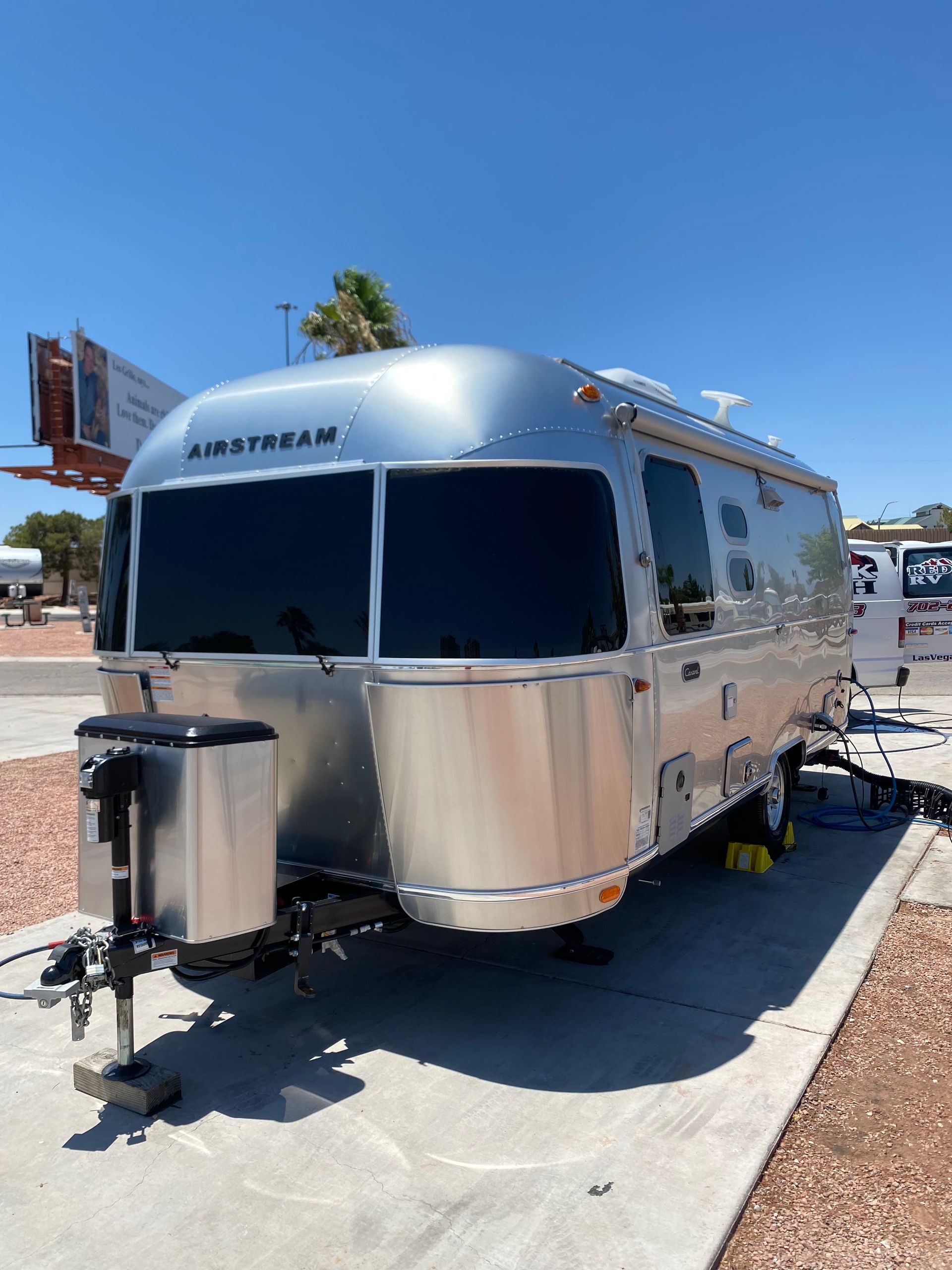 A silver airstream trailer is parked in a parking lot