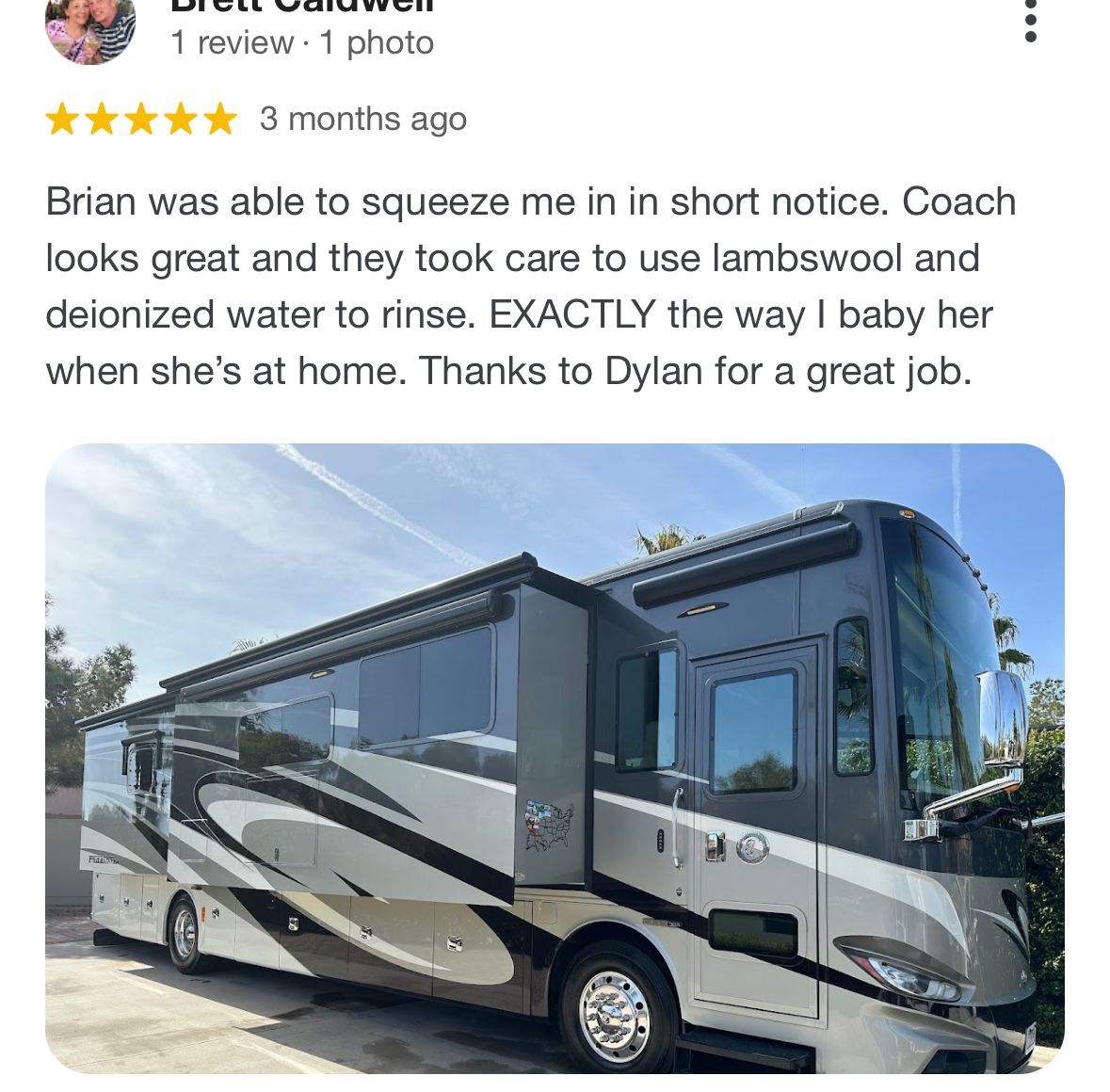 A large rv is parked in a driveway next to a house.