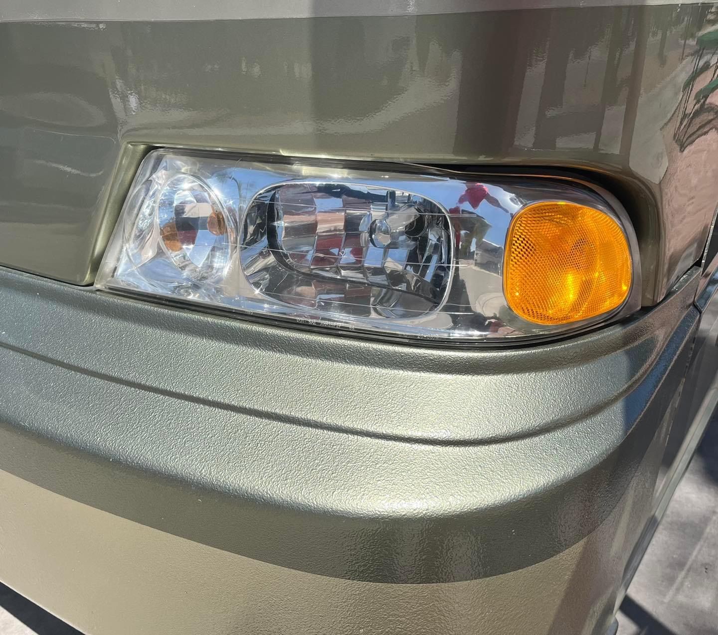 A close up of a car 's headlight and bumper.