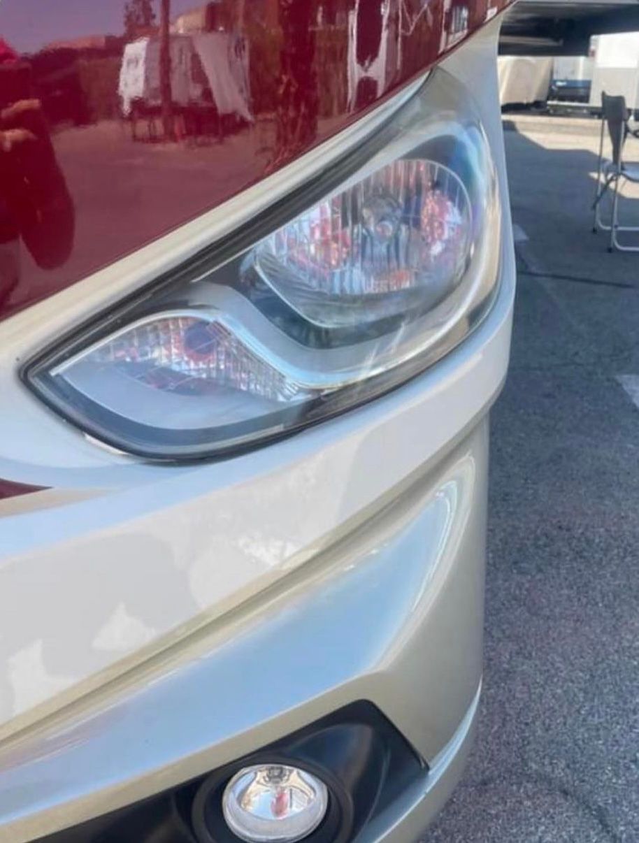 A close up of a red and white car 's headlight