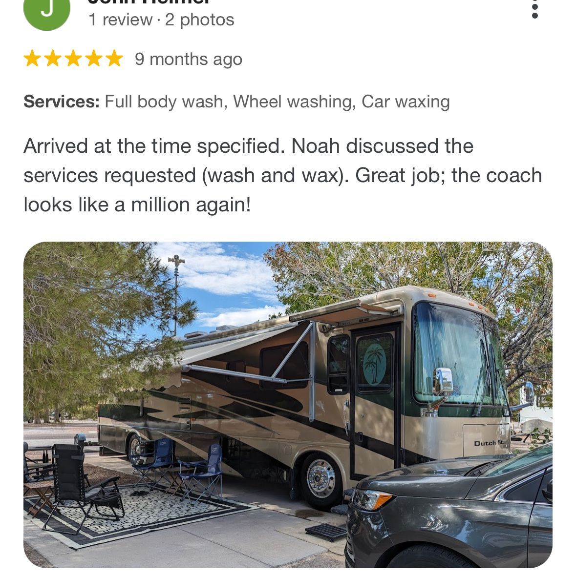 A rv is parked next to a car in a parking lot.