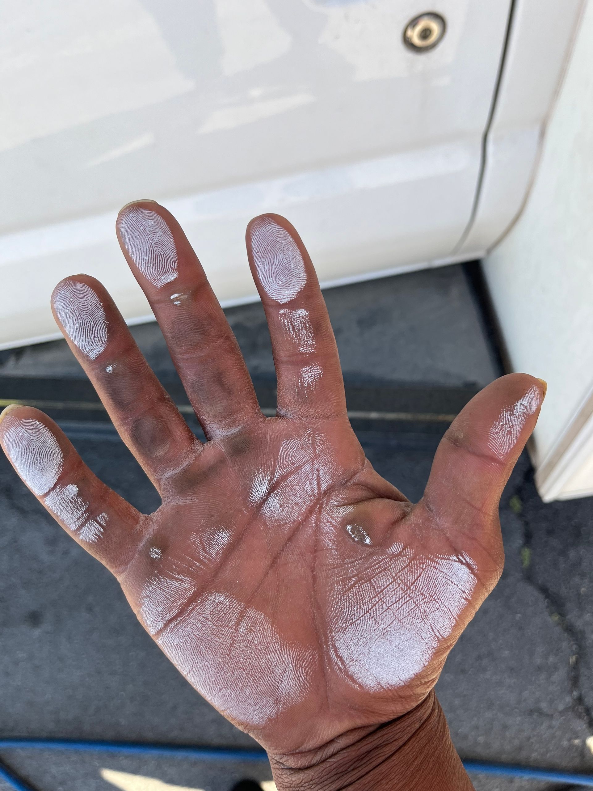 A person 's hand is covered in white paint