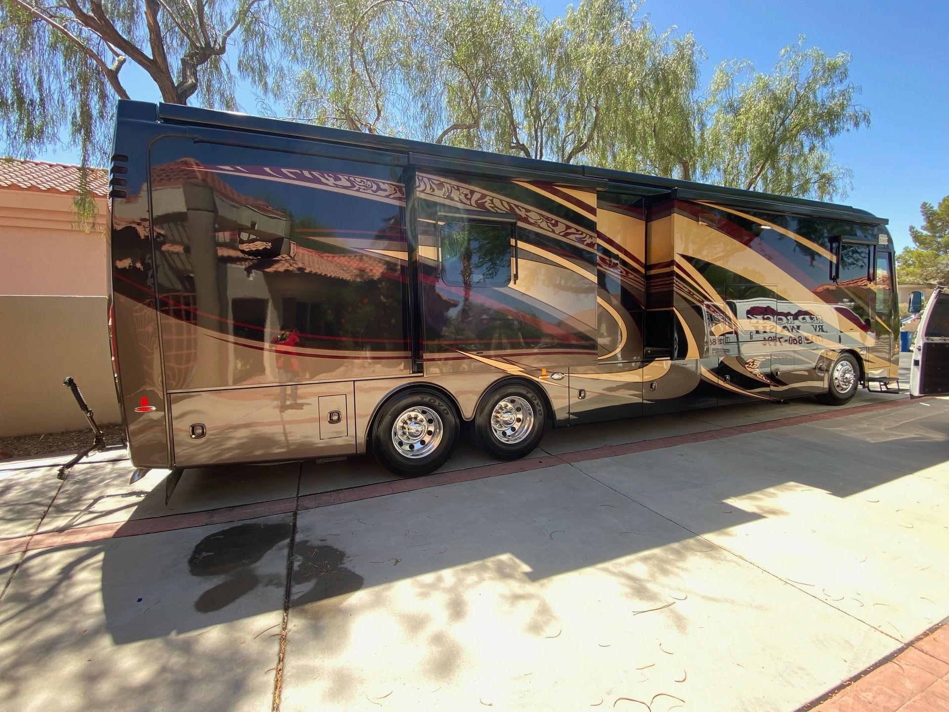 A large rv is parked on the side of the road.