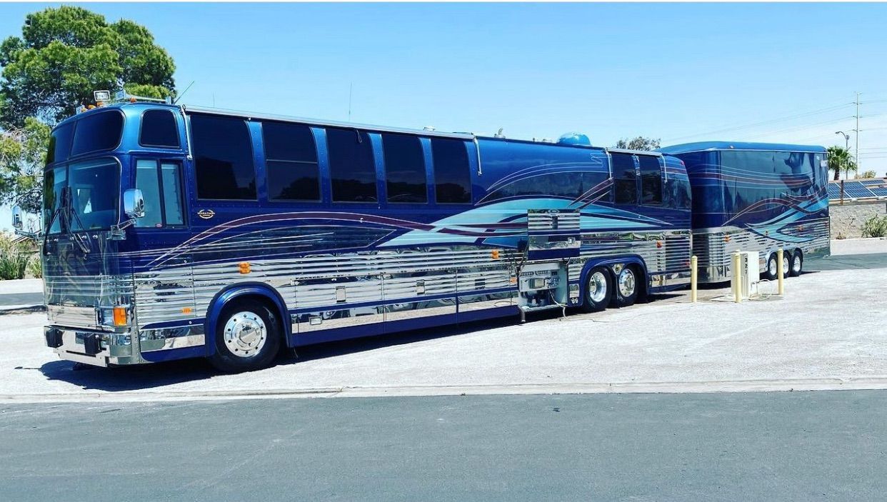 A large blue bus is parked on the side of the road.