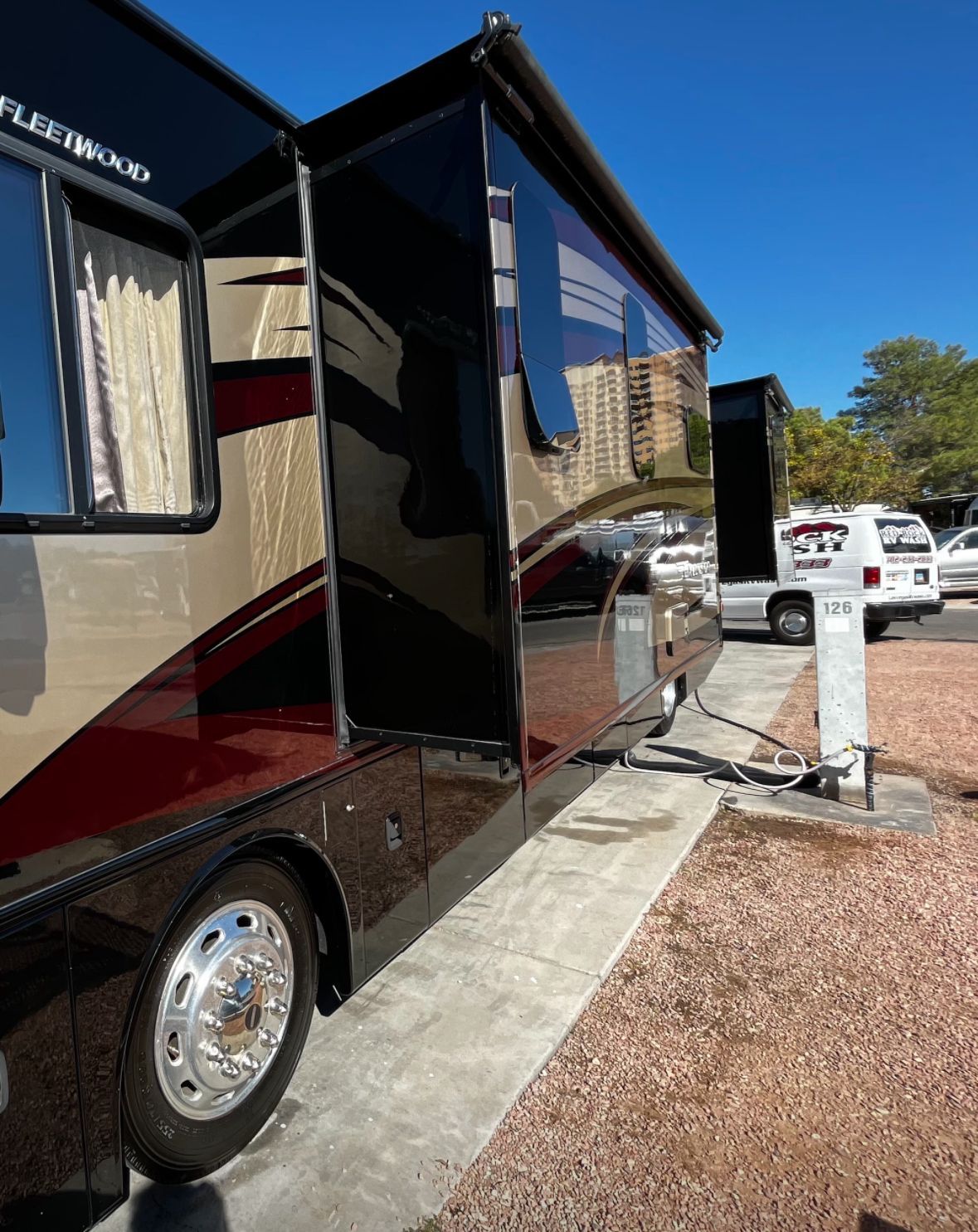 A rv is parked in a parking lot with the door open