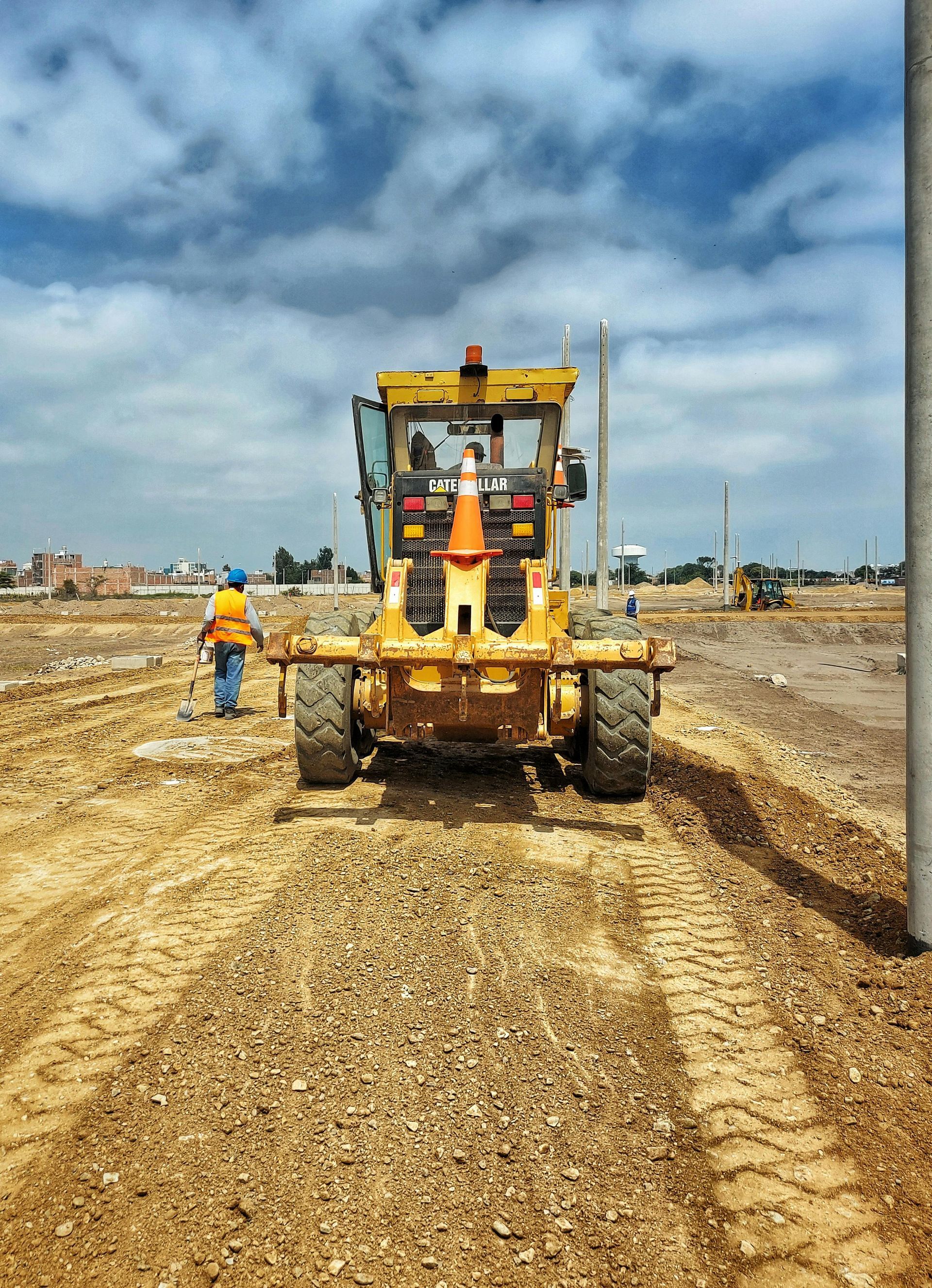 A yellow bulldozer is driving down a dirt road.