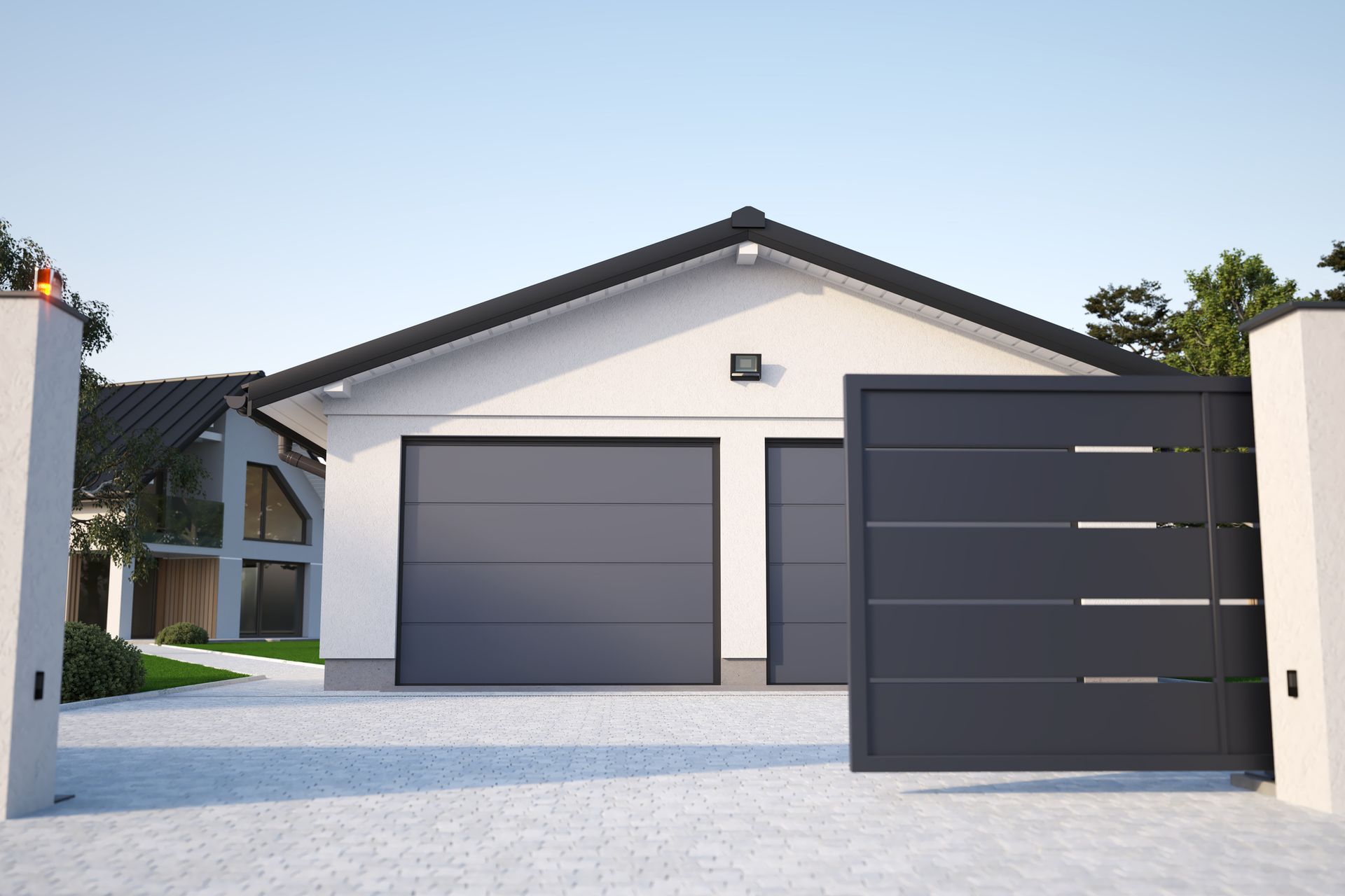 Gray garage with matching gate in front of a white house, a modern design with light-colored paving.
