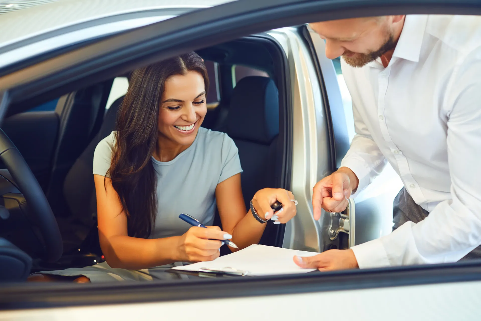 Woman signing documents inside a car | Brake World