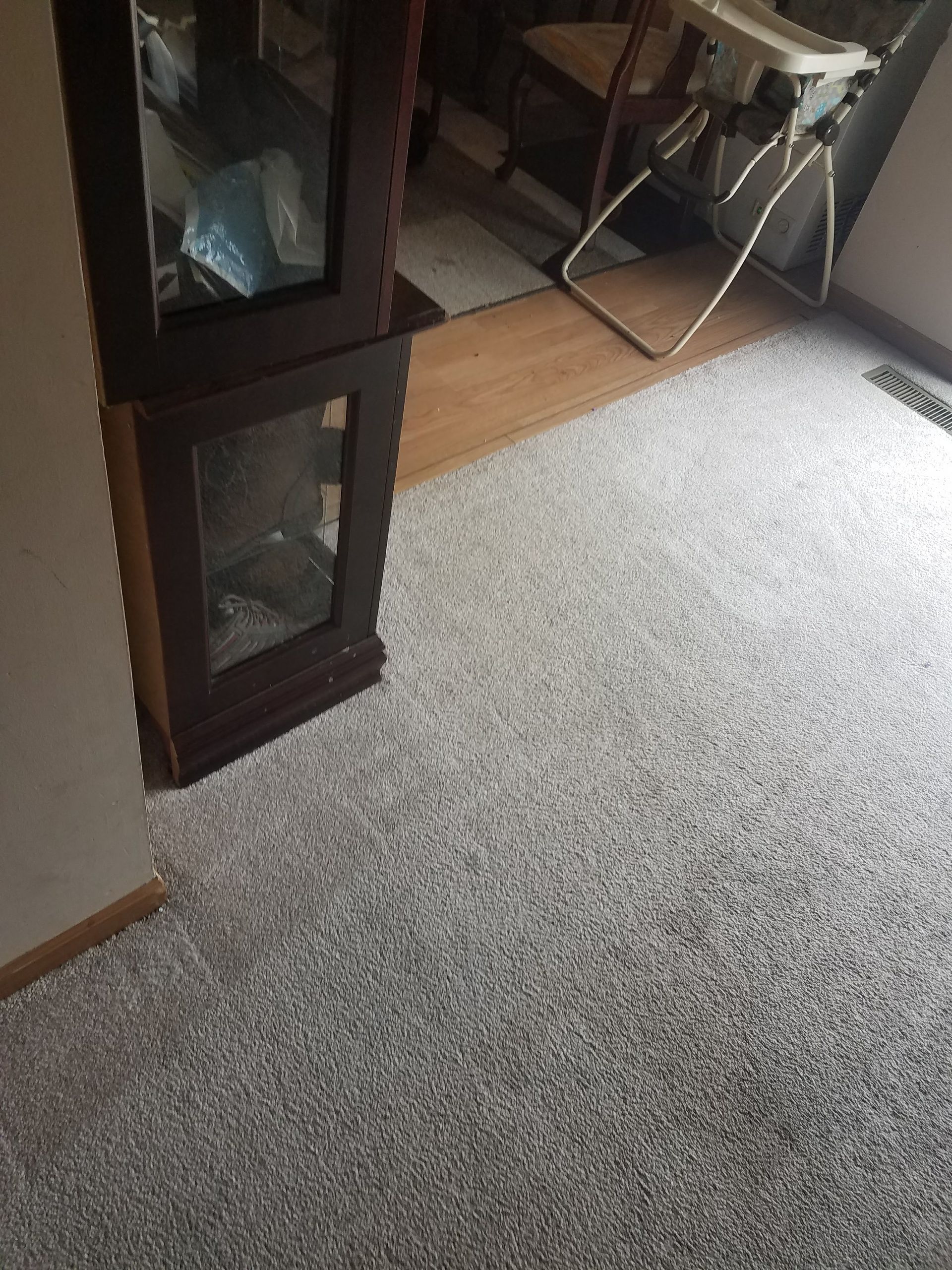 A room with a high chair and a carpeted floor