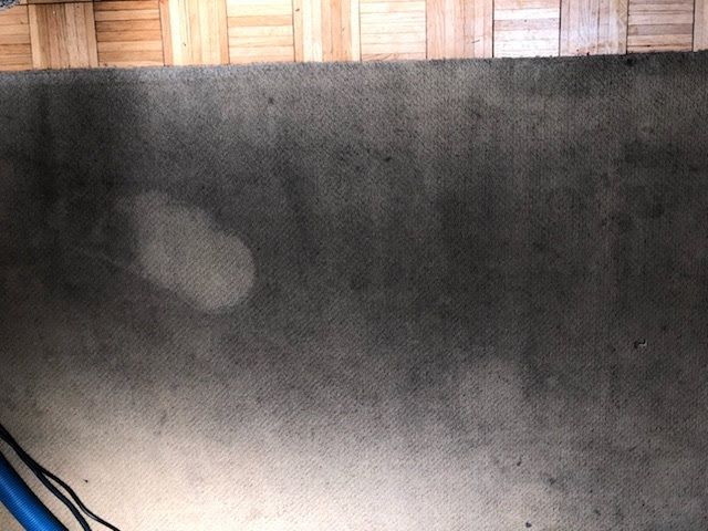 A dirty carpet is sitting on a wooden floor.