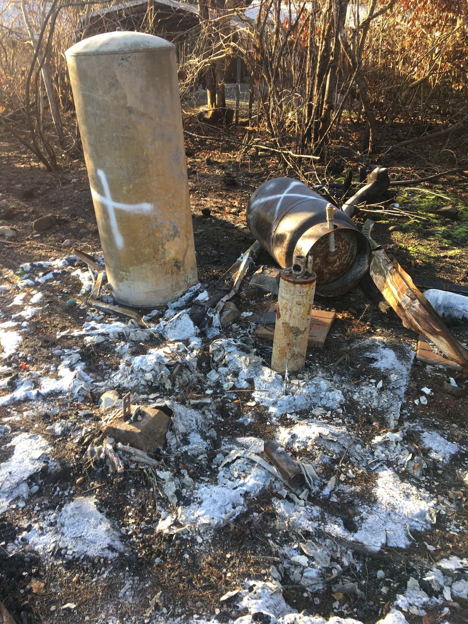 A statue of a spider with a cross painted on it is sitting in the dirt.